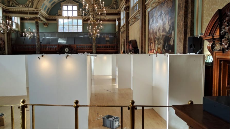 The exhibition walls going up in the Main Hall, seen from the balcony rail.
