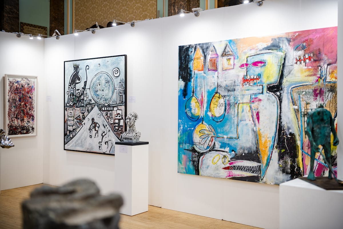 Large canvases hung edge to edge along the exhibition wall.