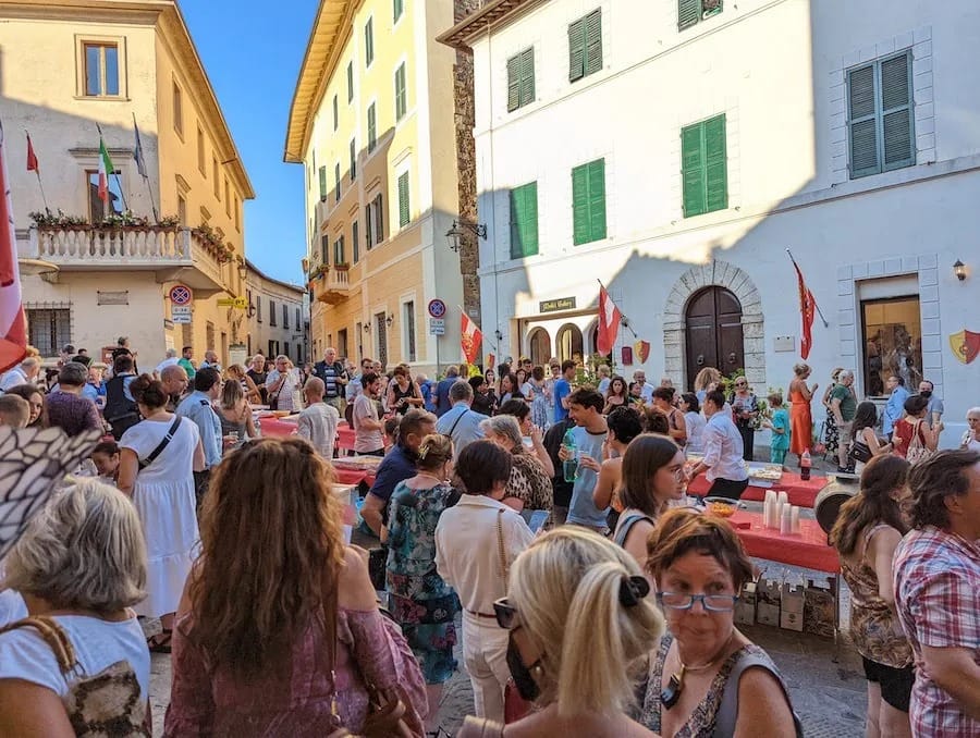 The piazza at festival time, flags out and the tables full.