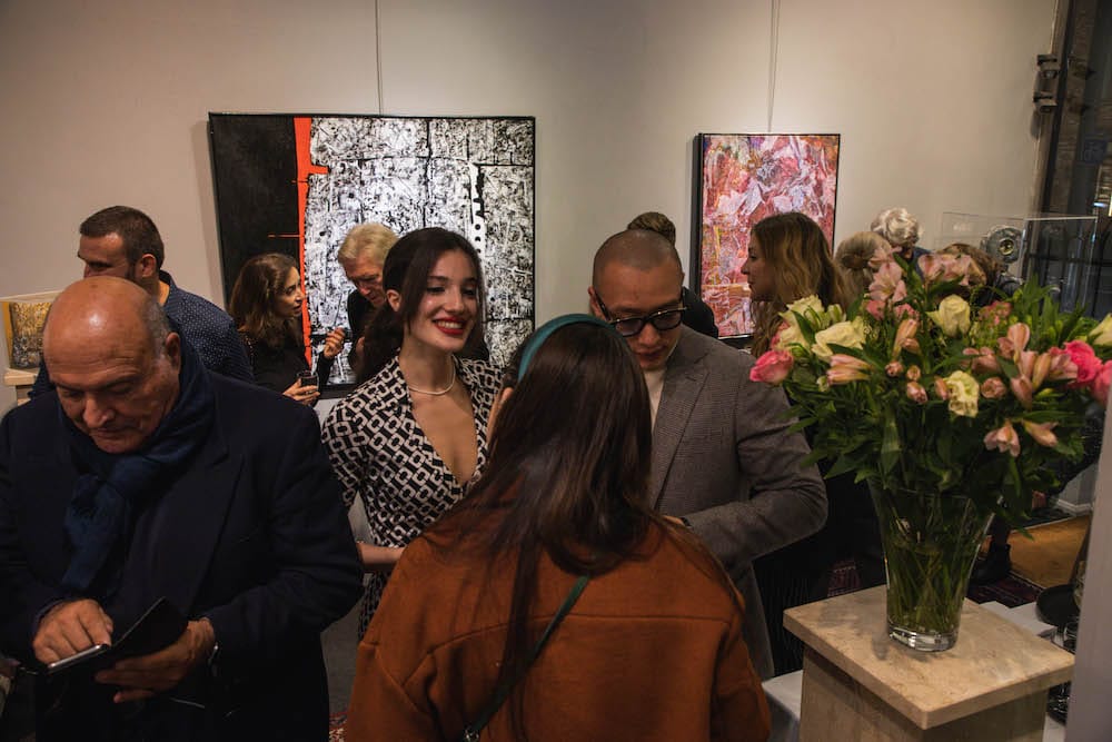Guests in conversation past the flowers.