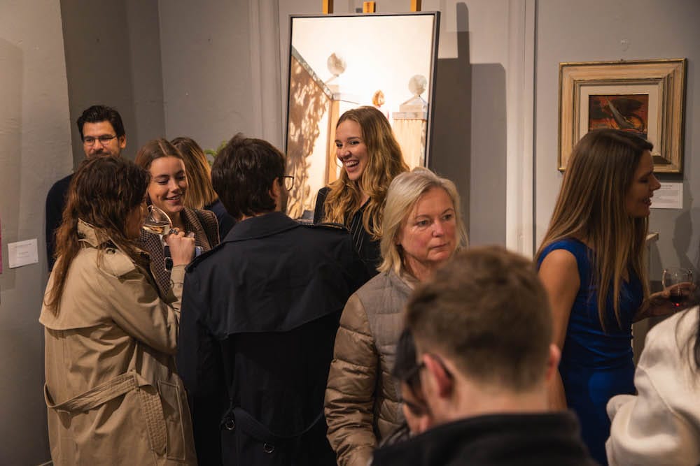 A group beside the tall canvas at the end of the room.