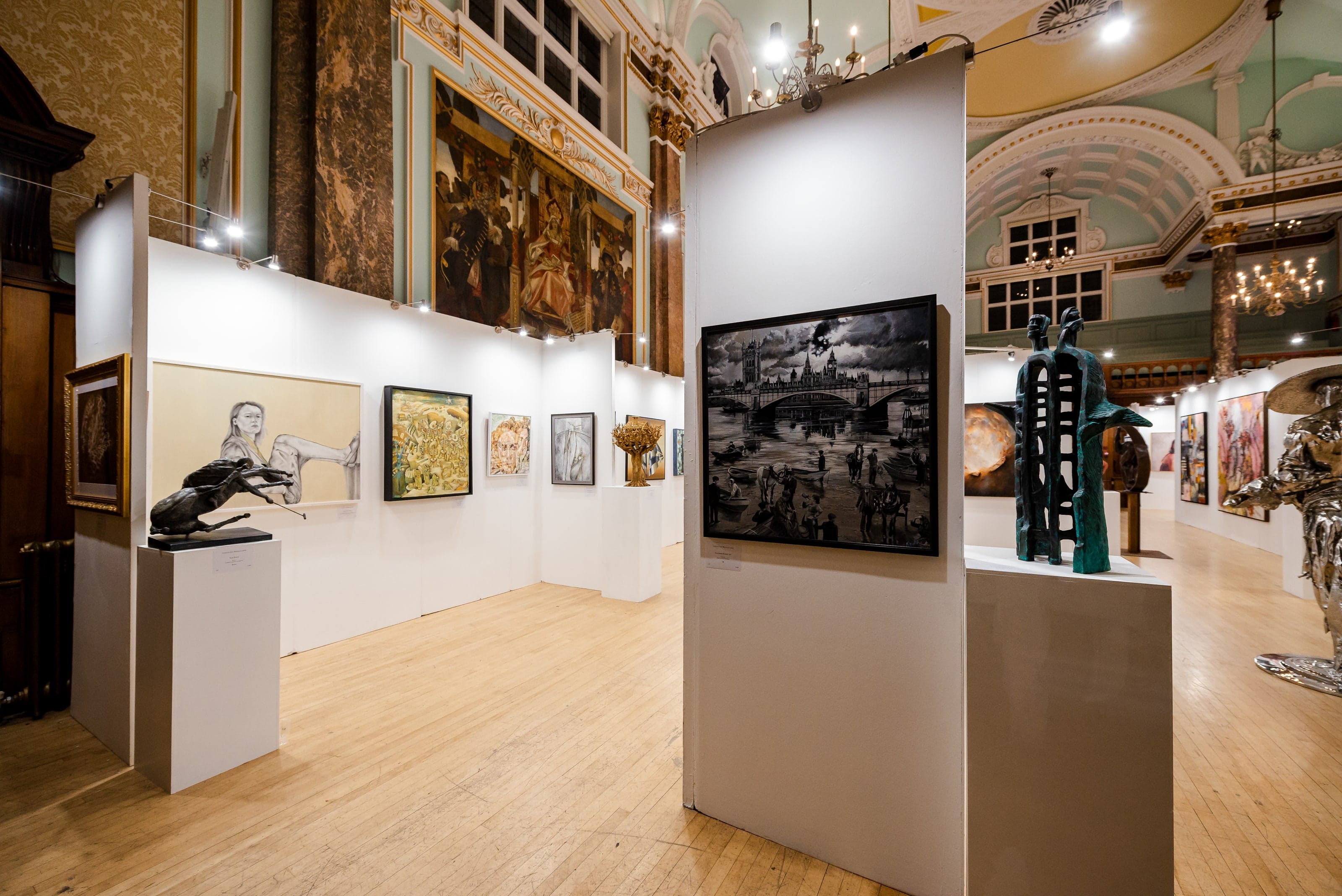 The 2023 exhibition looking down the length of the hall, bronzes and paintings on temporary white walls.