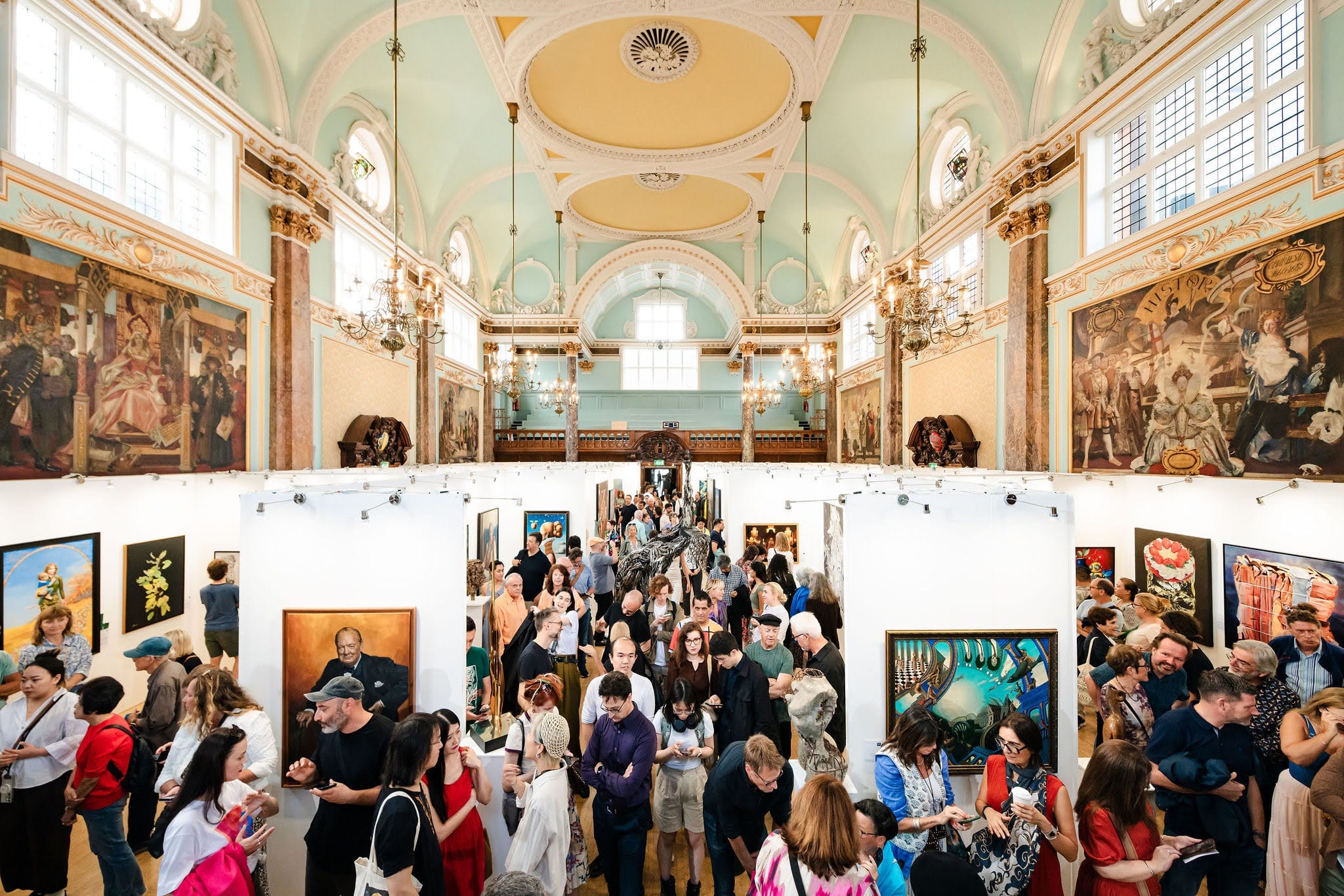 The main hall at capacity during the Biennale: the hang running the length of the room beneath the vaulted ceiling, visitors filling the floor between the walls.