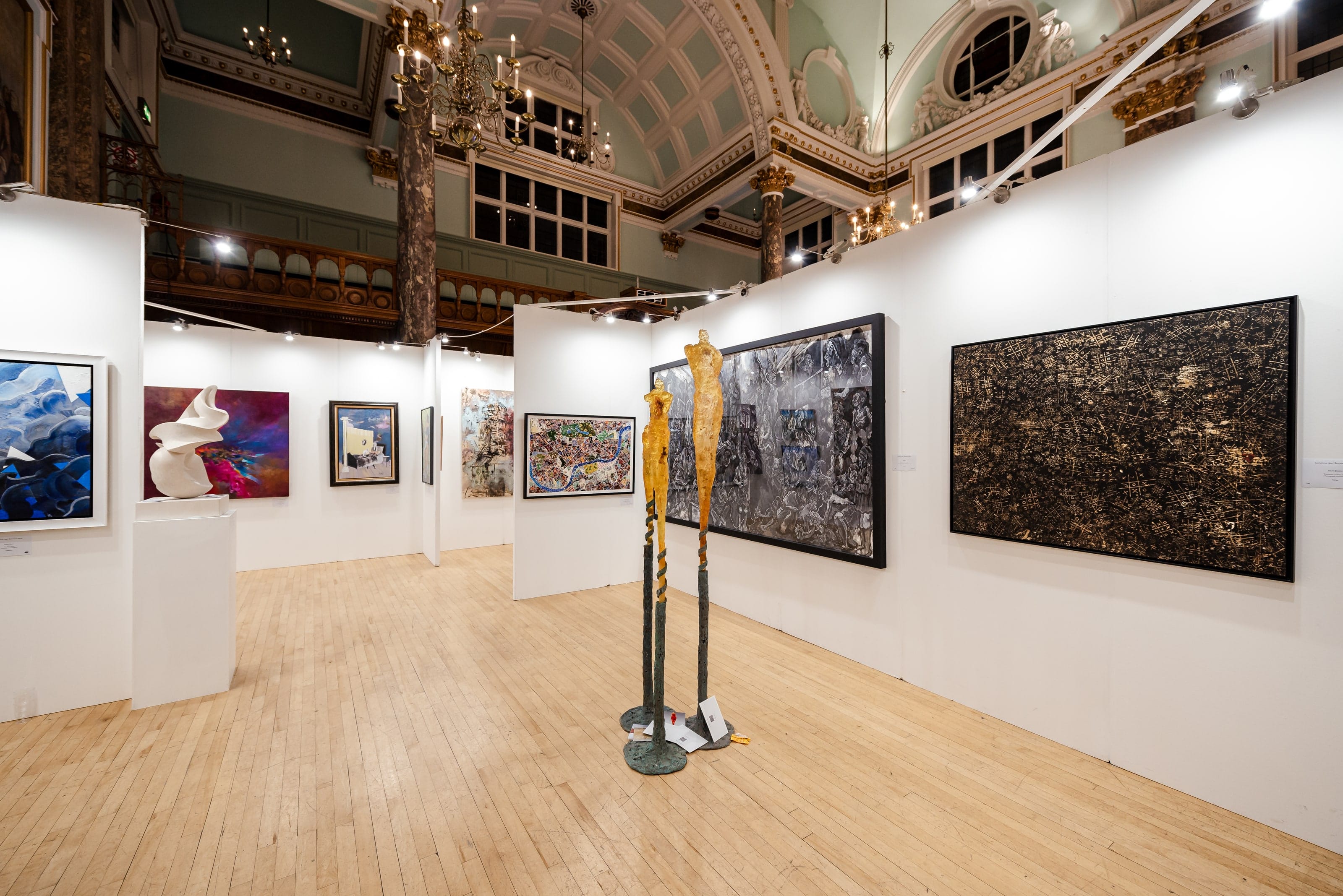 The main hall hung for the Sixth Edition, a tall bronze figure standing among the white walls.