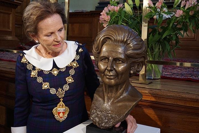 The Mayor of Kensington and Chelsea beside a bronze portrait bust.