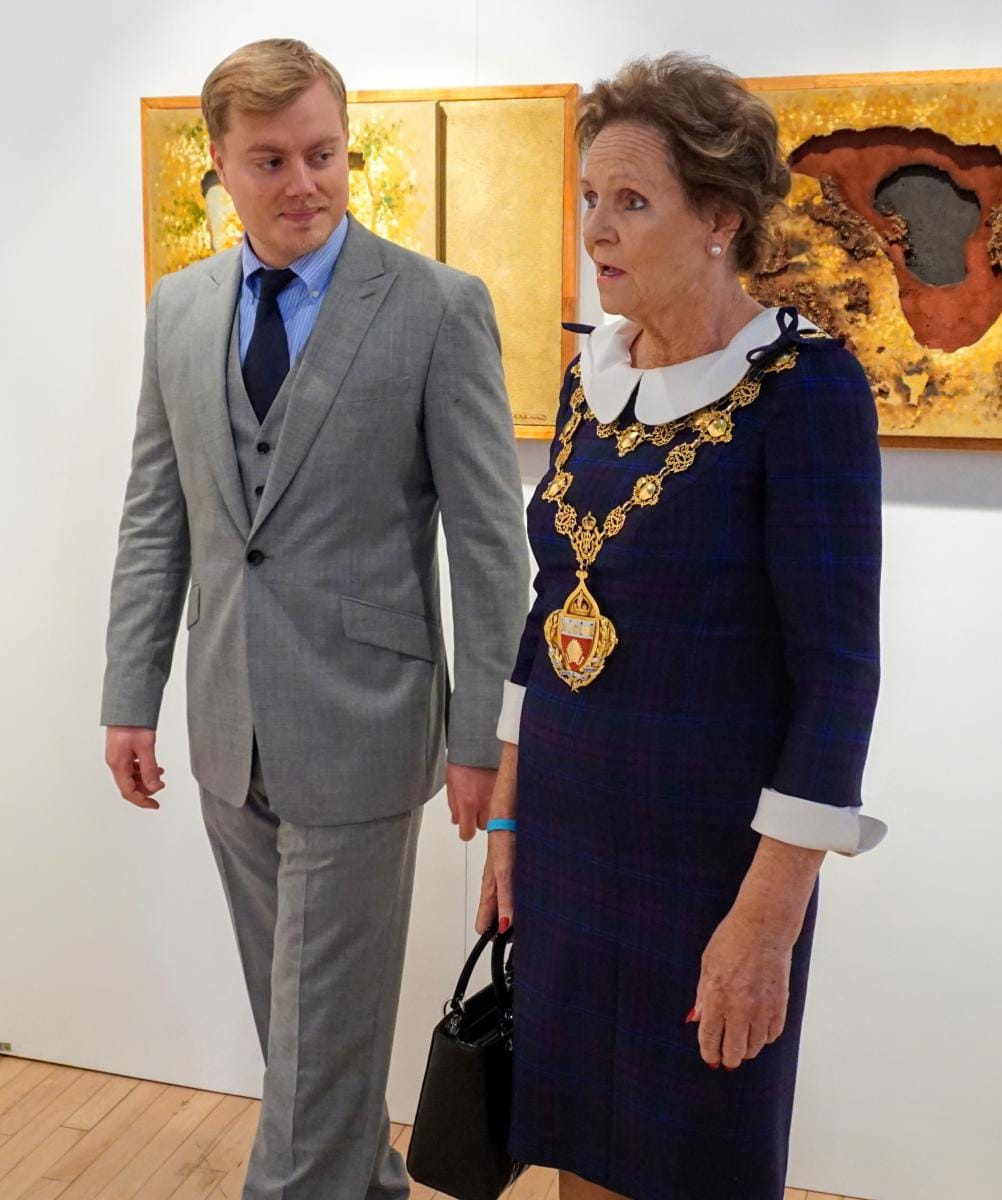 The Mayor of Kensington and Chelsea walking through the exhibition with a guest.