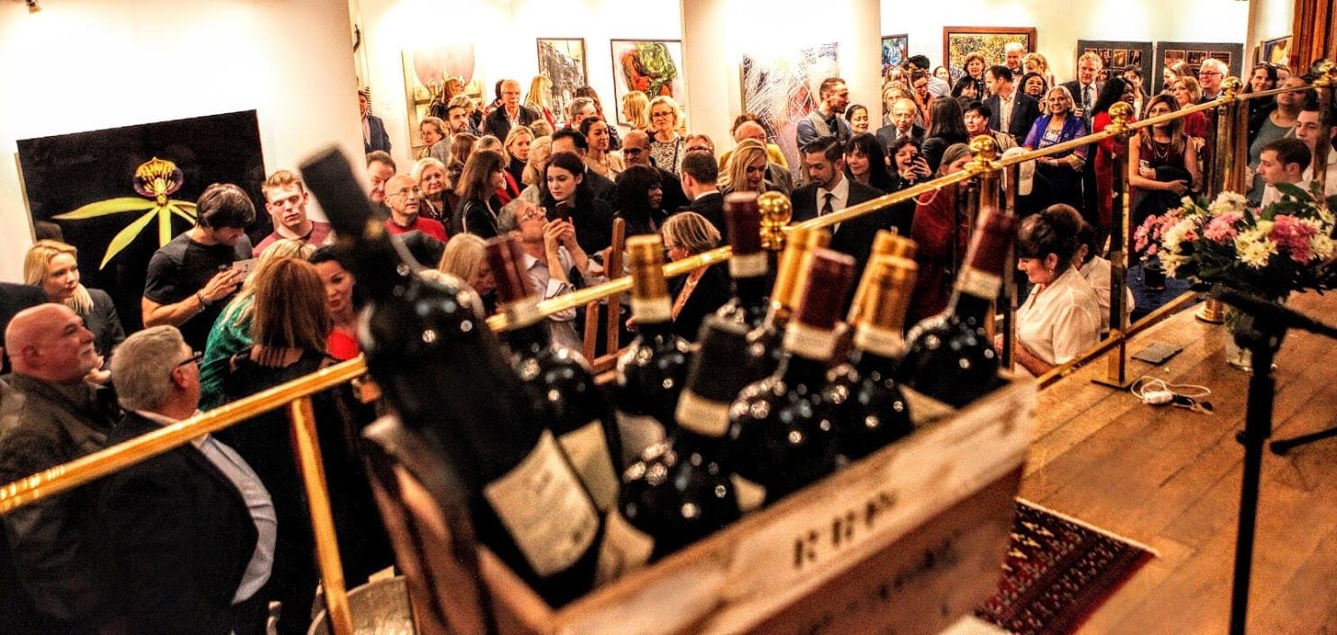The crowd at the vernissage, wine crates stacked along the bar.