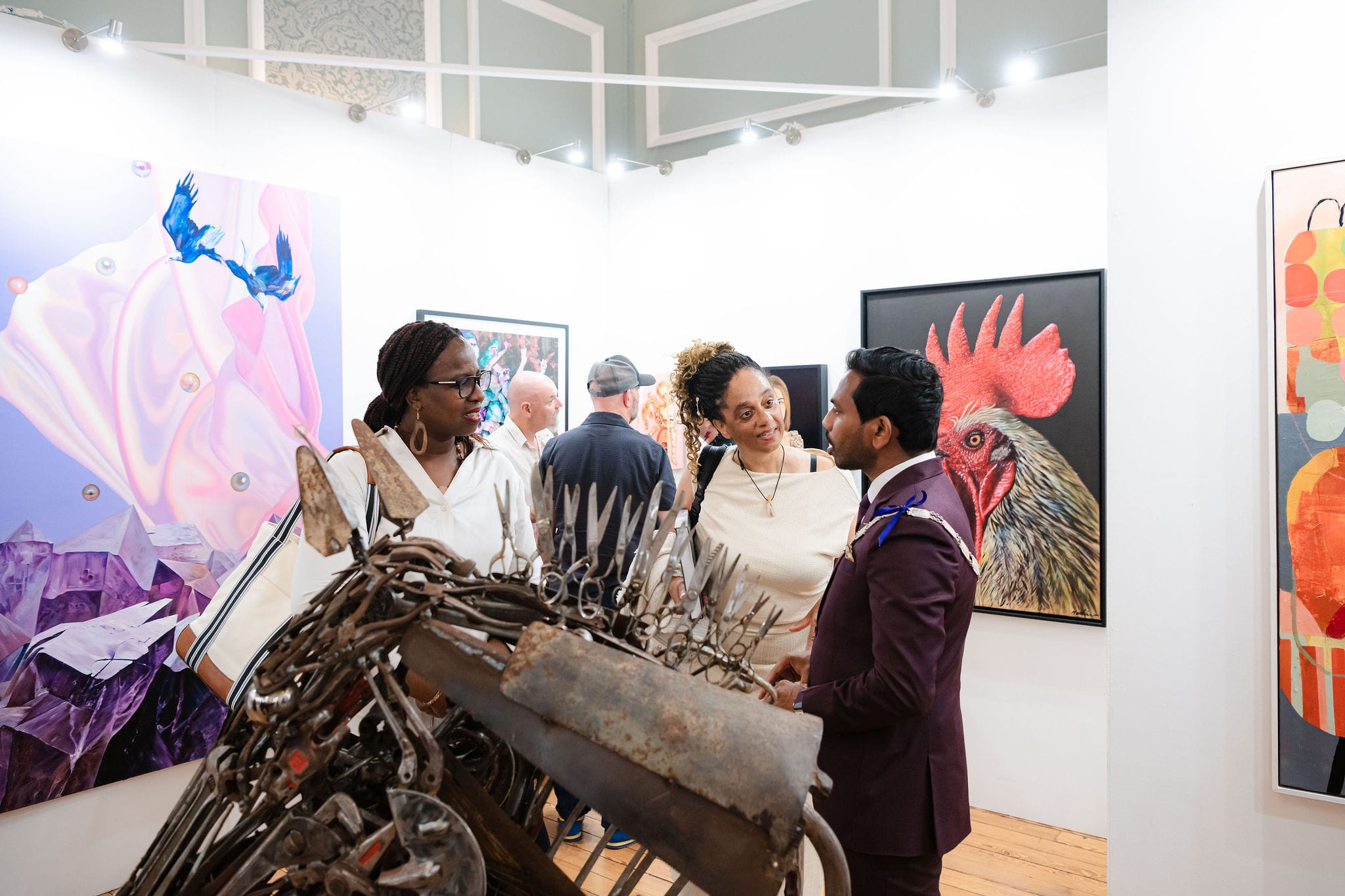 Visitors gathered around a large welded-metal rooster in the exhibition.