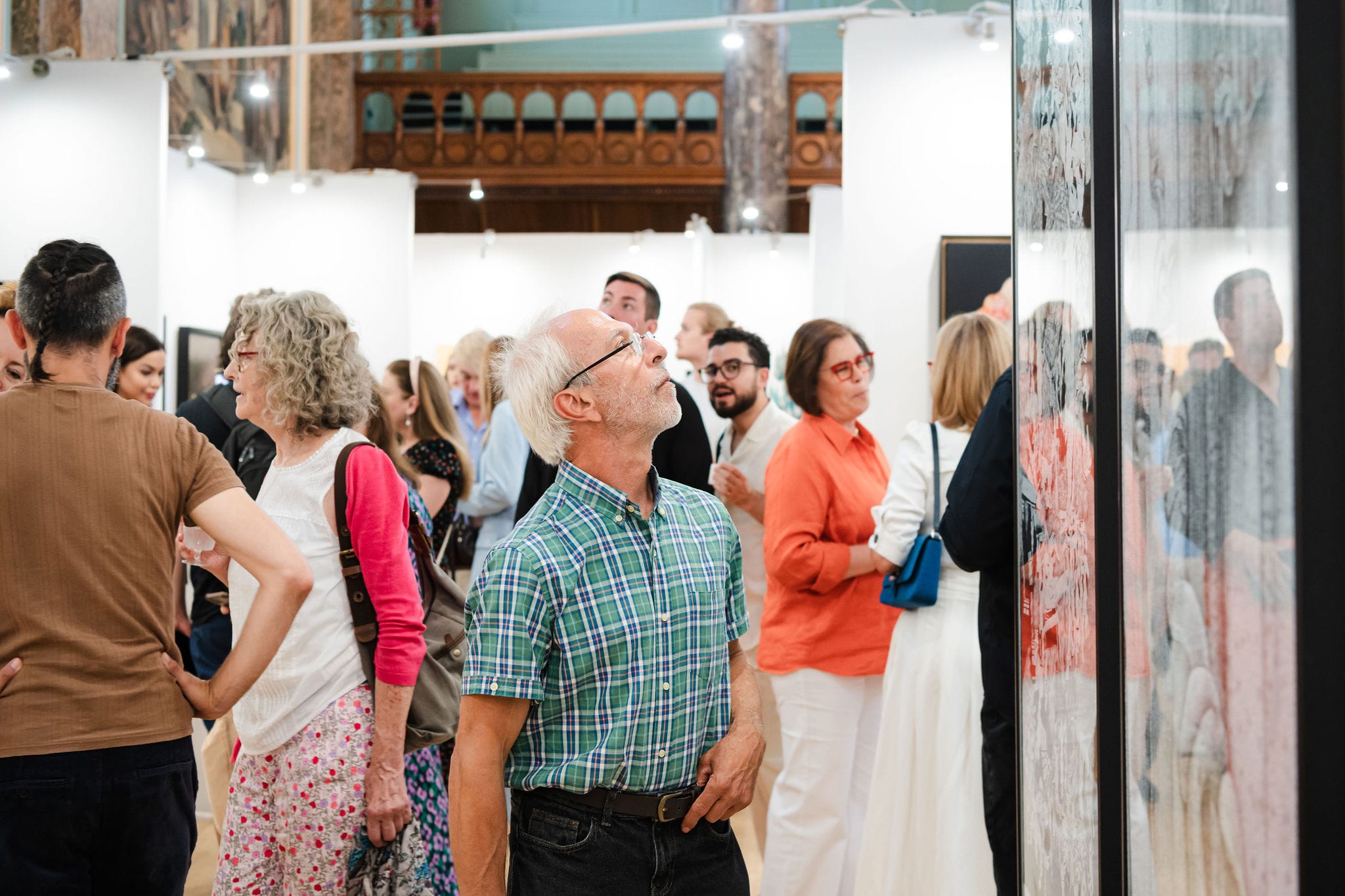 Visitors studying the wall of prints.